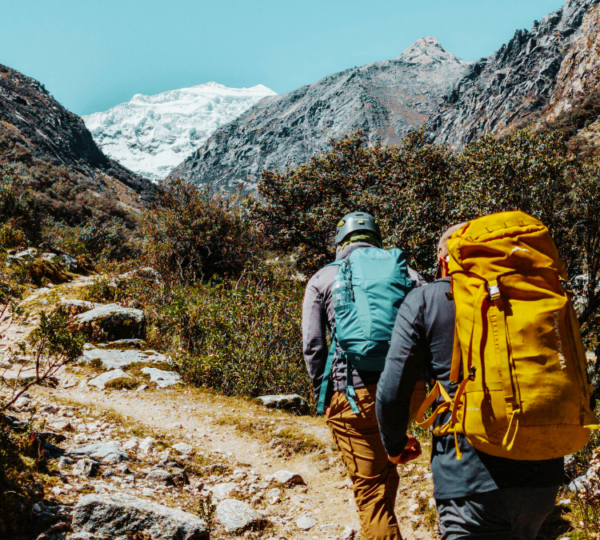 a couple of men trekking up a low grade mountain