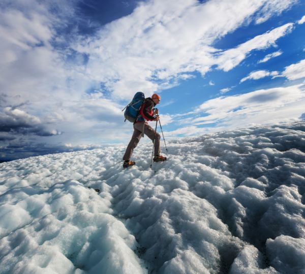 a man trekking on top of glacier ice
