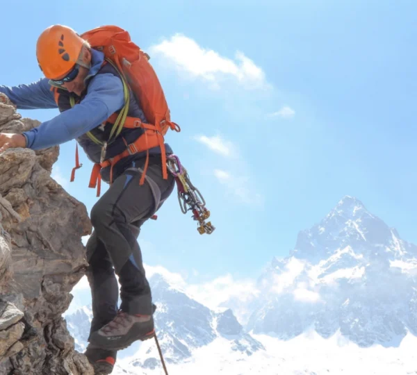 a man scaling down a mountain rock